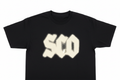 Black cotton tee with discharge-printed bleached cream logo, flat fabric-like surface